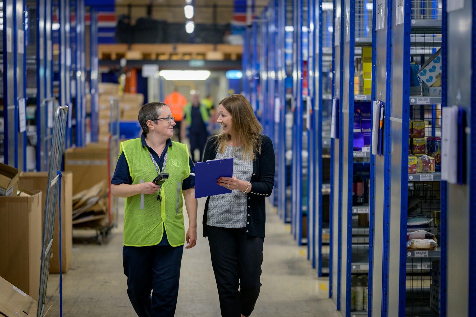 Warehouse staff reviewing order details with a clipboard before release.