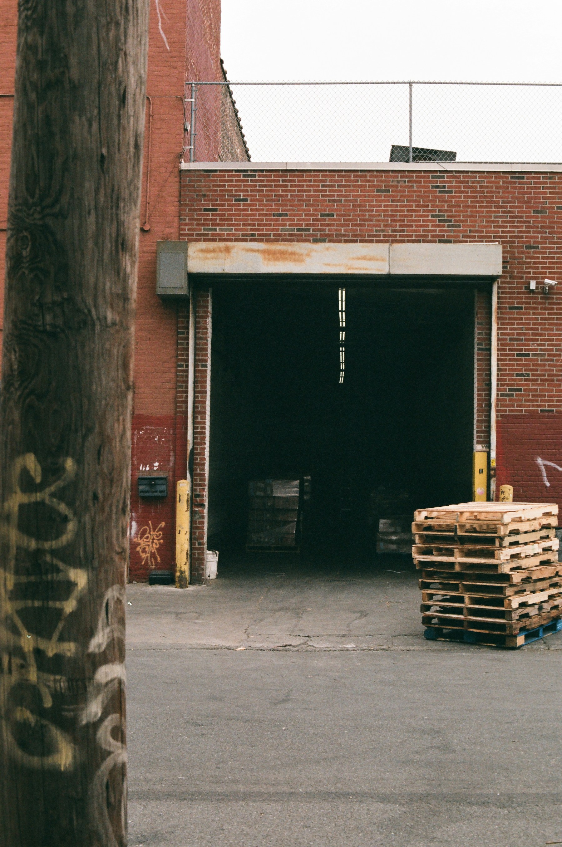 Warehouse loading dock with stacked wooden pallets.