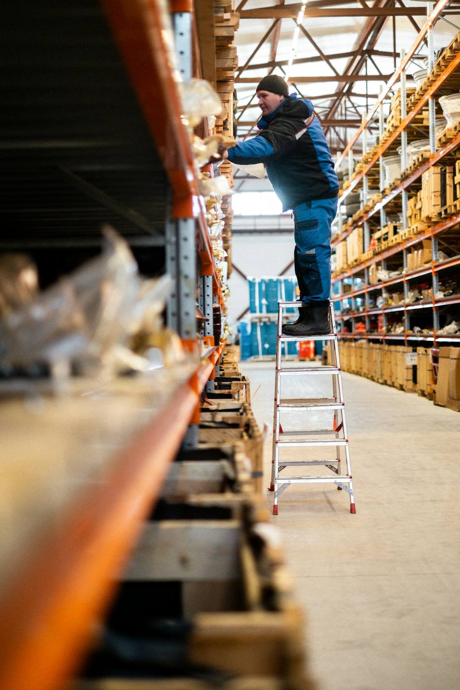 Warehouse worker selecting inventory for STZINC route-first contact intake.